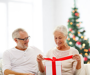 Image showing happy senior couple with gift box at home