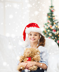 Image showing smiling girl in santa helper hat with teddy bear