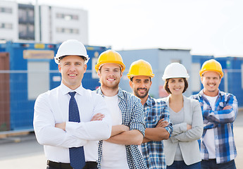 Image showing group of smiling builders in hardhats outdoors