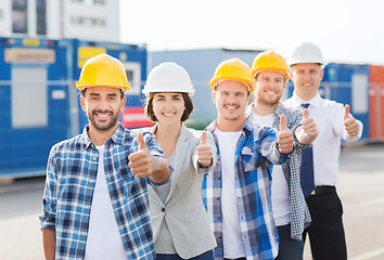 Image showing group of smiling builders in hardhats outdoors