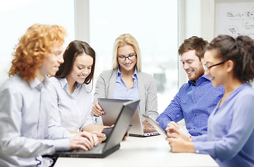 Image showing smiling team with laptop and table pc computers