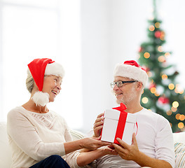 Image showing happy senior couple with gift box at home