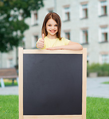 Image showing happy little girl with blank blackboard