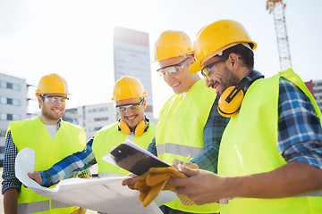 Image showing group of builders with tablet pc and blueprint