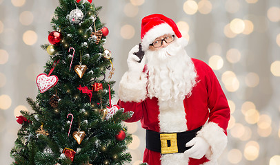 Image showing santa claus with smartphone and christmas tree