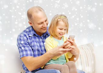 Image showing happy father and daughter with smartphone