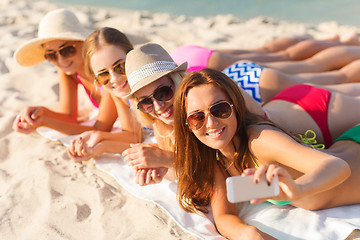 Image showing group of smiling women with smartphone on beach