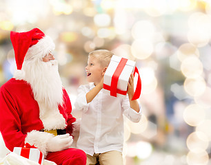 Image showing smiling little boy with santa claus and gifts