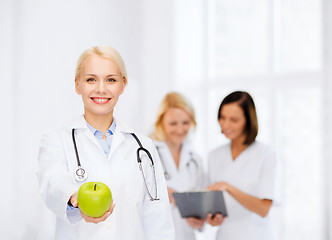 Image showing smiling female doctor with green apple