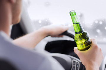 Image showing close up of man drinking alcohol while driving car