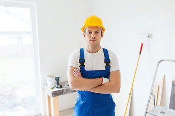 Image showing builder in hardhat with working tools indoors