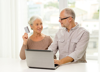 Image showing happy senior couple with laptop and credit card