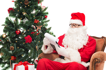 Image showing man in costume of santa claus with notepad