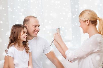 Image showing happy family with camera taking picture at home