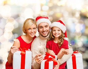 Image showing happy family in santa helper hats with gift boxes