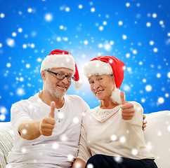 Image showing happy senior couple in santa helper hats