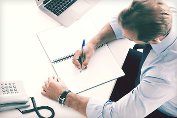 Image showing businessman writing in notebook