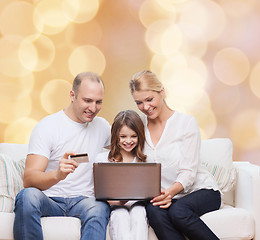 Image showing happy family with laptop computer and credit card