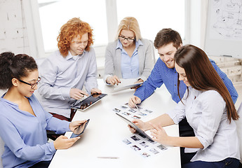 Image showing smiling team with table pc and papers working