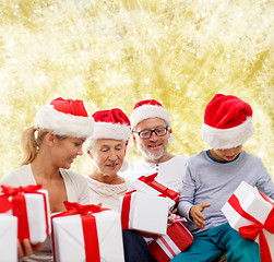 Image showing happy family in santa helper hats with gift boxes