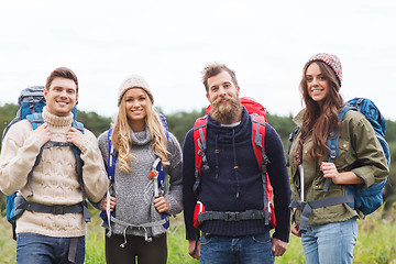 Image showing group of smiling friends with backpacks hiking