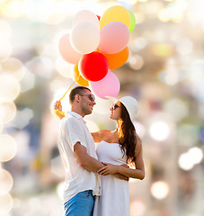 Image showing smiling couple with air balloons outdoors