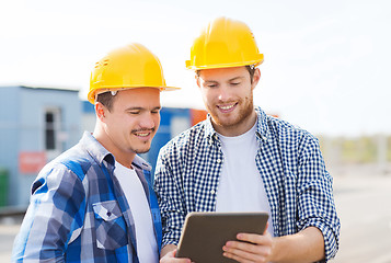 Image showing smiling builders in hardhats with tablet pc