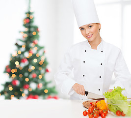 Image showing smiling female chef chopping vegetables