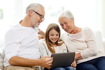 Image showing smiling family with tablet pc at home