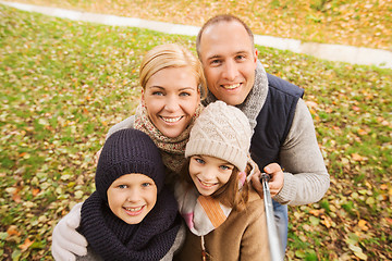 Image showing happy family with selfie stick in autumn park