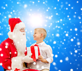 Image showing smiling little boy with santa claus and gifts