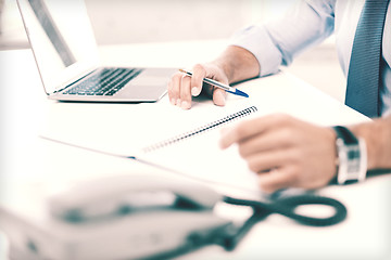 Image showing businessman writing in notebook