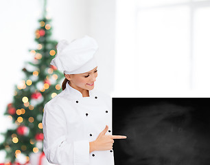 Image showing smiling female chef with white blank board