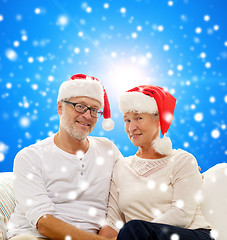 Image showing happy senior couple in santa helper hats