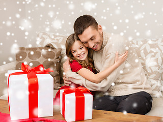 Image showing smiling father and girl with gift boxes hugging