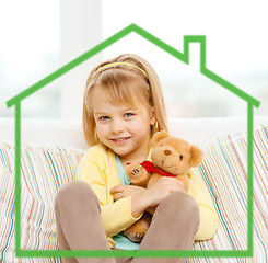 Image showing smiling girl with teddy bear sitting on sofa