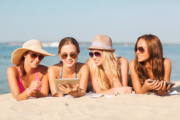 Image showing group of smiling young women with tablets on beach