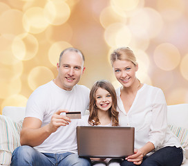 Image showing happy family with laptop computer and credit card