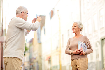 Image showing senior couple photographing on city street