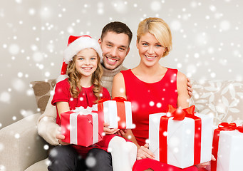 Image showing smiling family holding many gift boxes