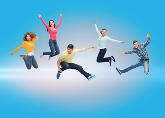 Image showing group of smiling teenagers jumping in air