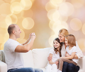 Image showing happy family with camera at home