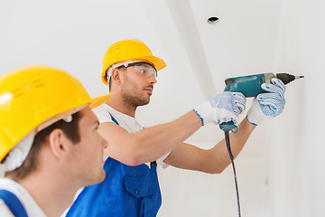 Image showing group of builders with drill indoors
