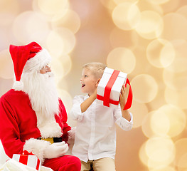 Image showing smiling little boy with santa claus and gifts