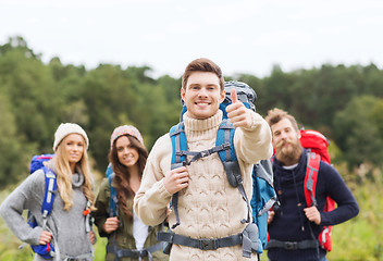 Image showing group of smiling friends with backpacks hiking