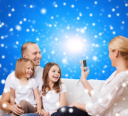 Image showing happy family with camera at home