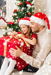 Image showing smiling father and daughter holding gift box