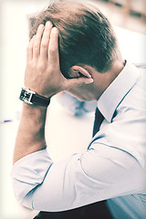 Image showing stressed businessman with papers at work