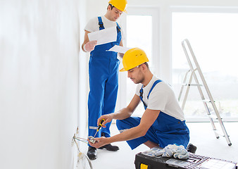 Image showing builders with tablet pc and equipment indoors