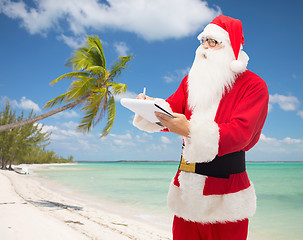 Image showing man in costume of santa claus with notepad